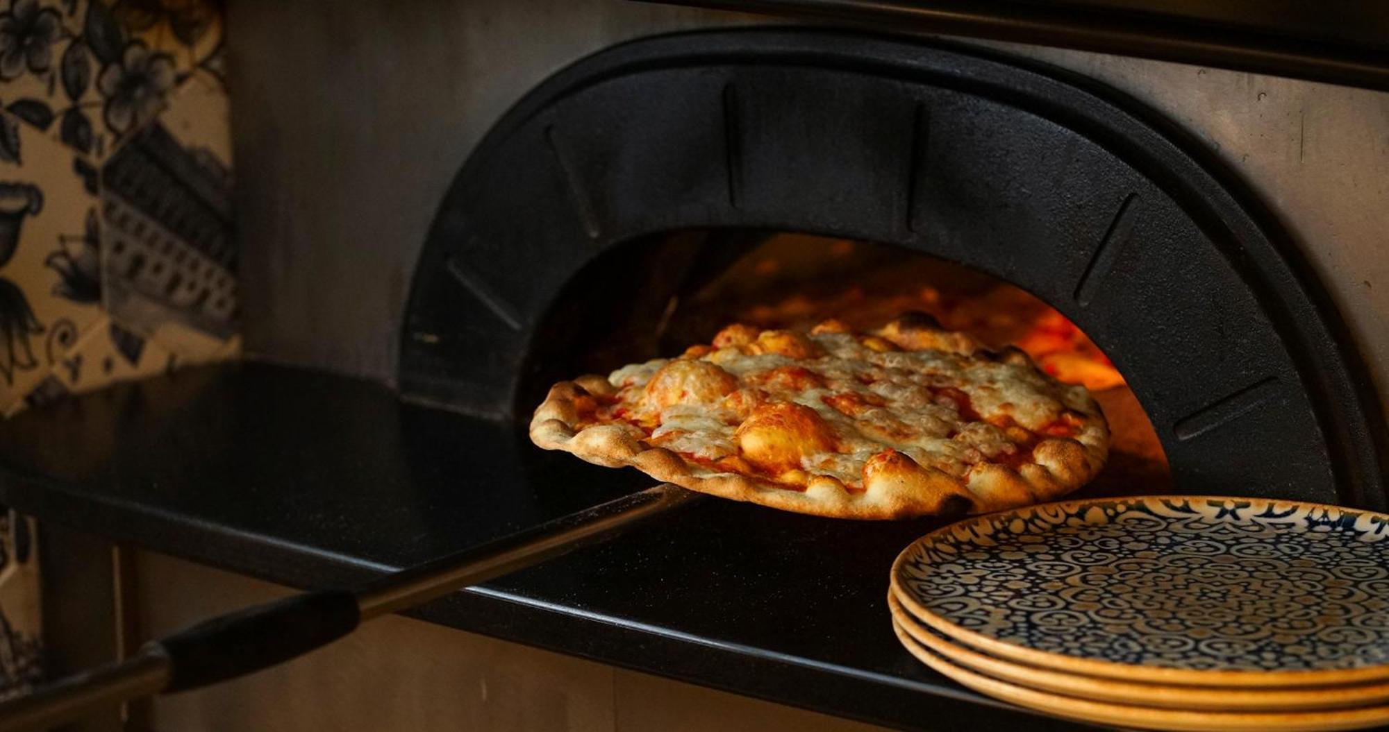 Eme Catedral Mercer Hotel Σεβίλλη Εξωτερικό φωτογραφία Pizza being removed from a wood-fired oven